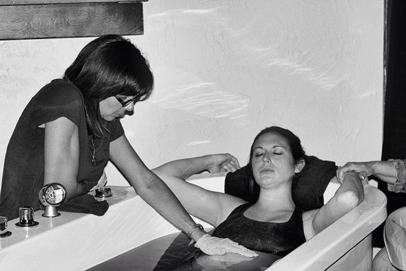 midwife coaching mother through water birth - Heavenly Hands Birthing Center
