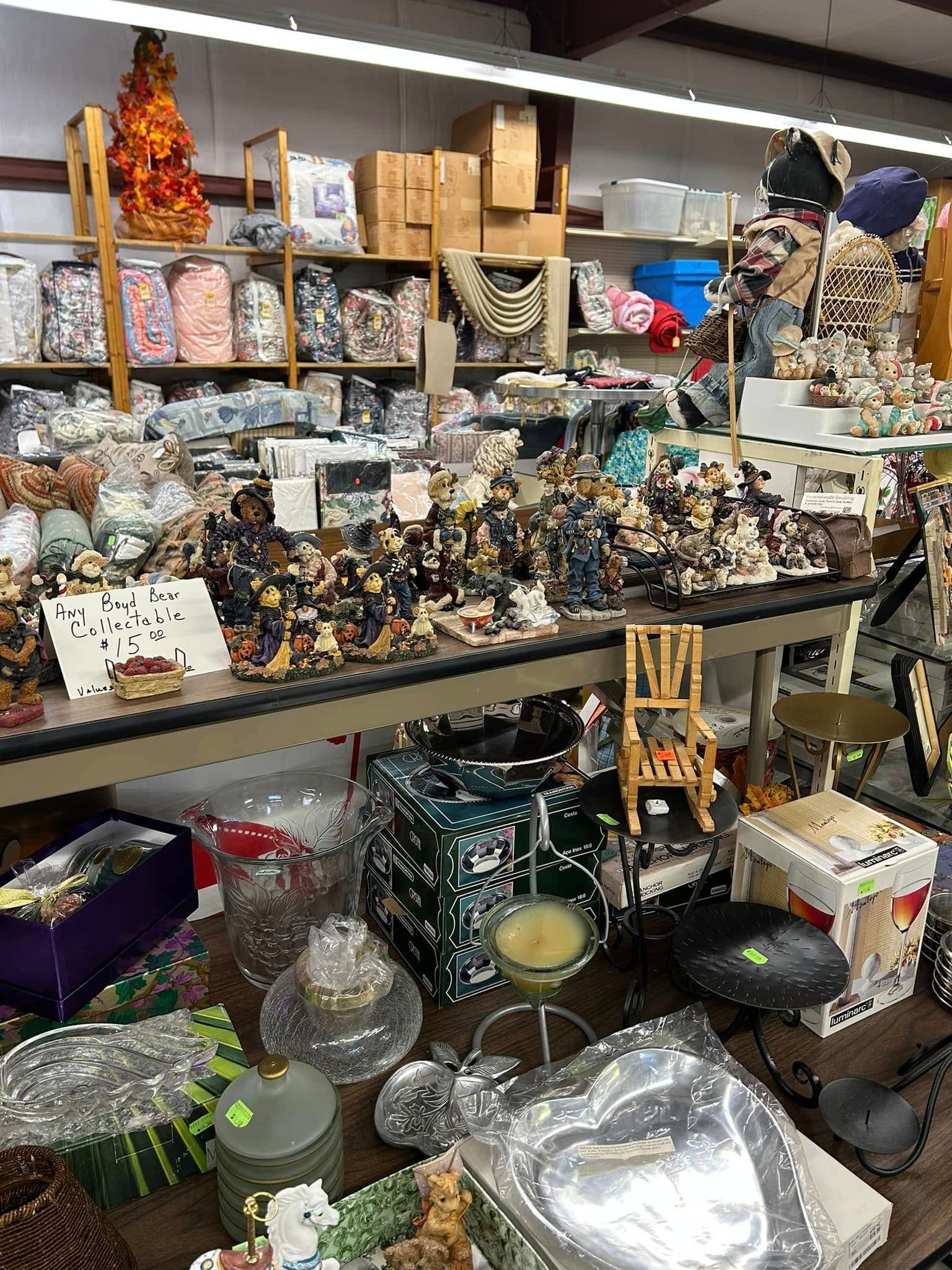 Shelves of assorted figurines and household goods in a cluttered indoor market stall