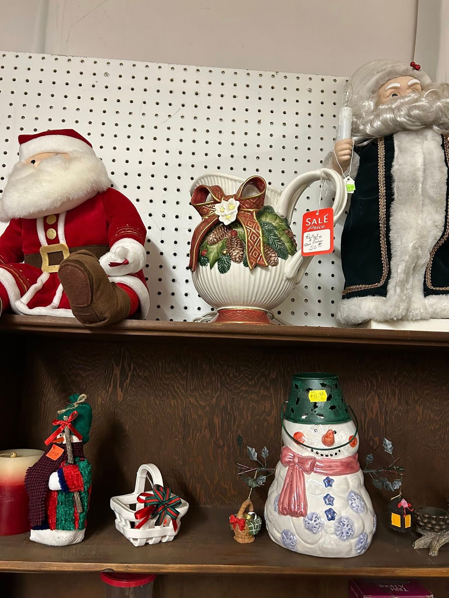 Holiday figurines on store shelves, including Santa, a snowman, and a penguin in a pearl-shell ornament