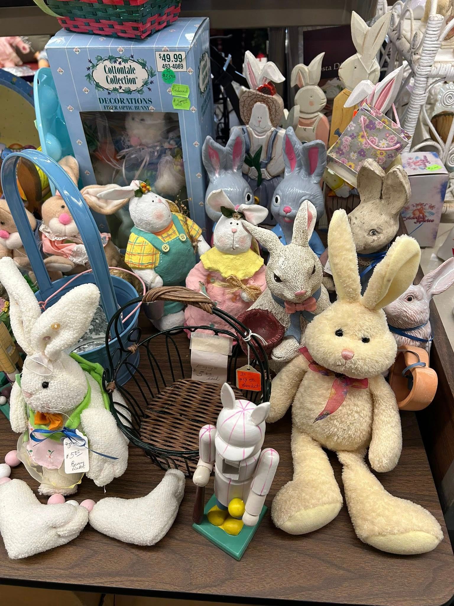 Stuffed bunny display in a shop, with large cream and white rabbits and pastel Easter decorations.