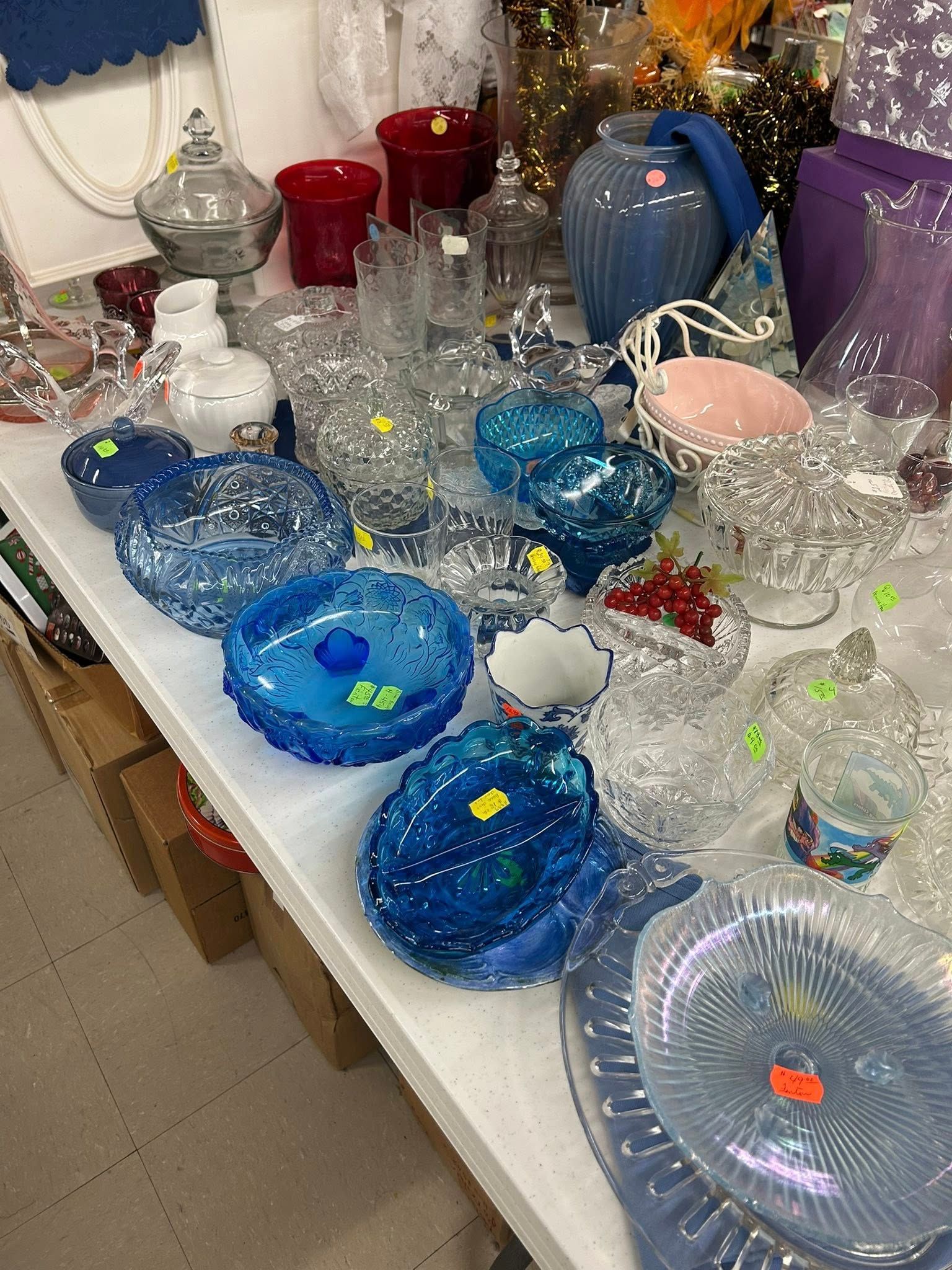 Assorted colorful glass bowls and vases arranged on a table, wrapped in bubble wrap.