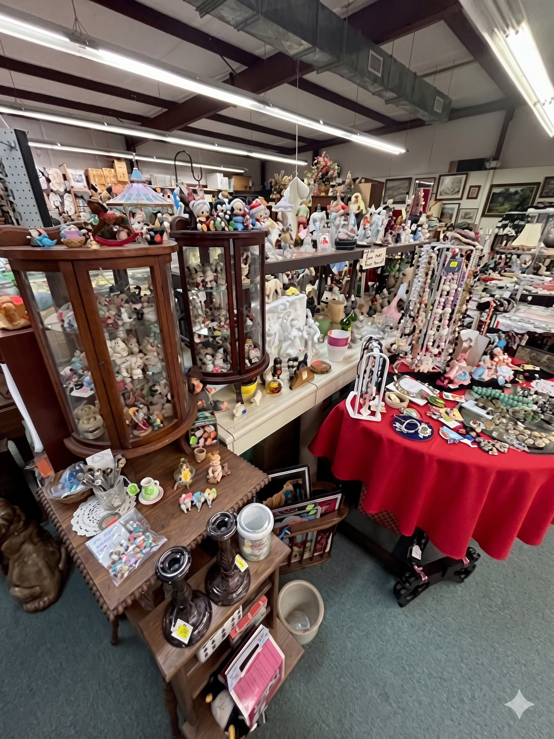 Halloween craft display with orange-and-black plush decorations, garlands, and small spooky figurines on shelves