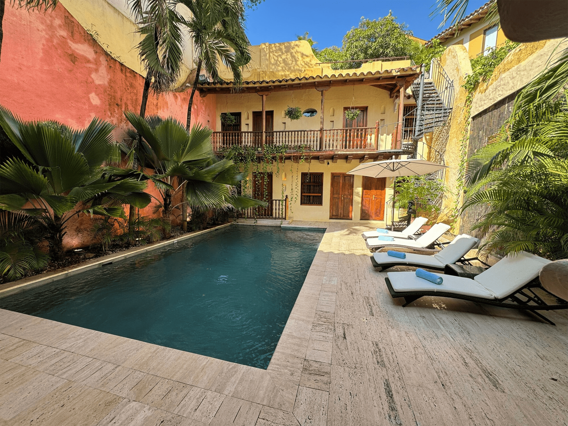 Una gran piscina rodeada de tumbonas frente a un edificio.
