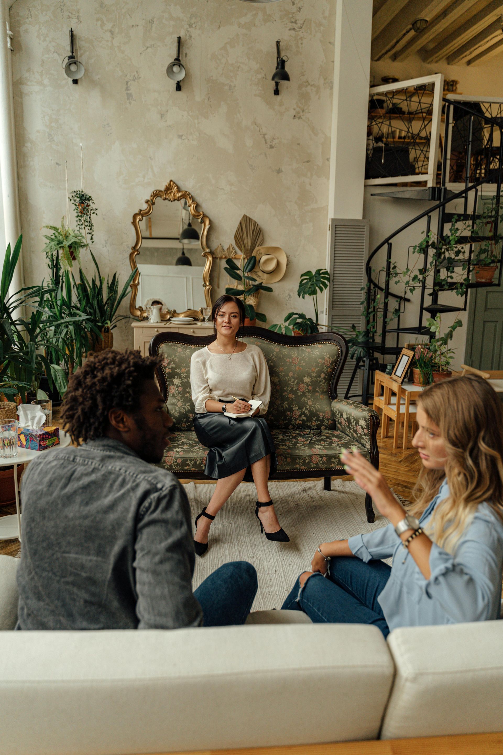 Woman in white jacket smiles while on a call and holding a tablet outside a modern building.