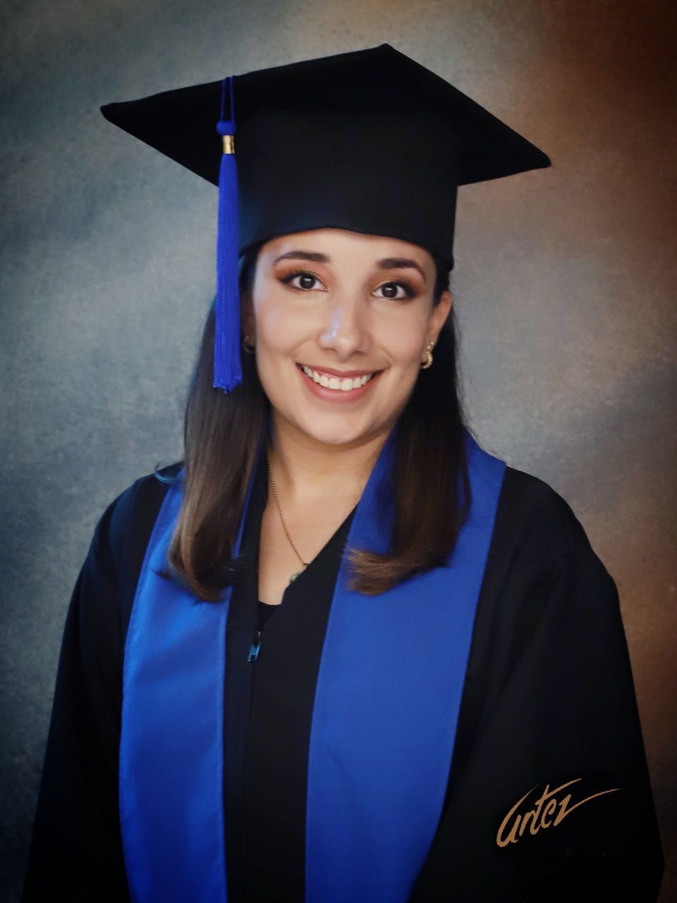 Una mujer que llevaba una toga y birrete de graduación con el nombre cortez en la manga