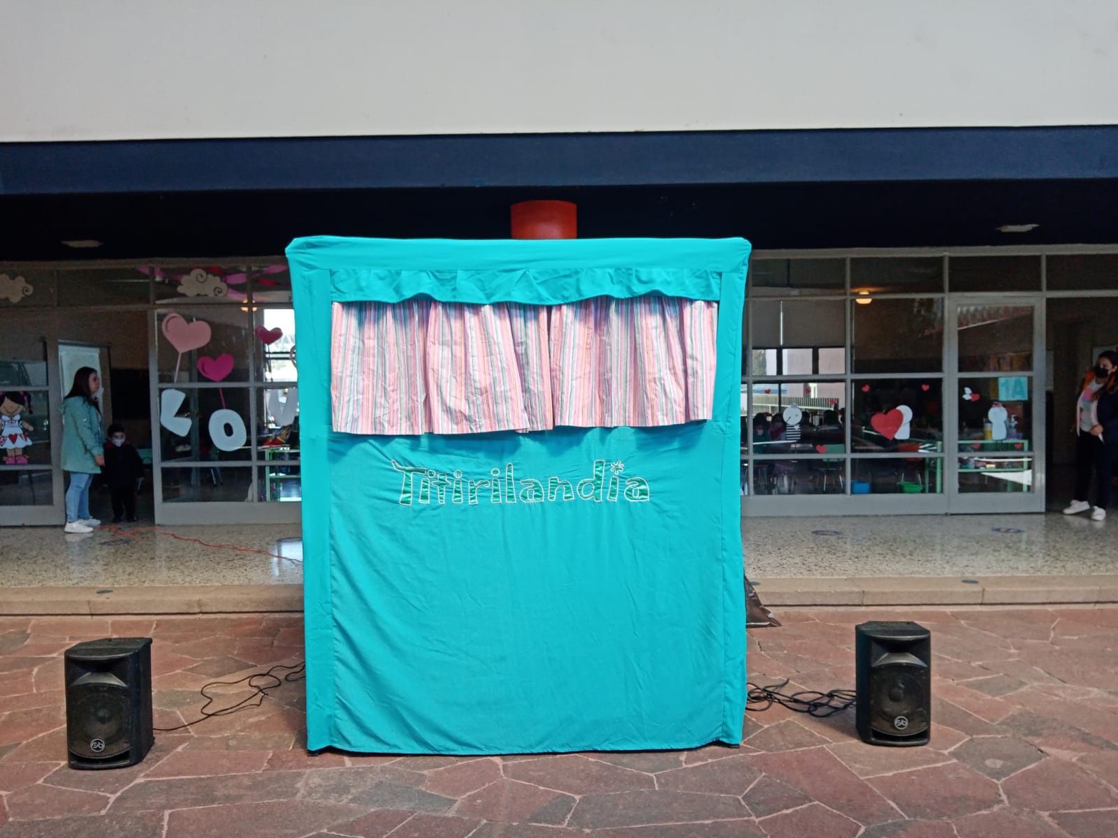 Un teatro de marionetas está sentado frente a un edificio