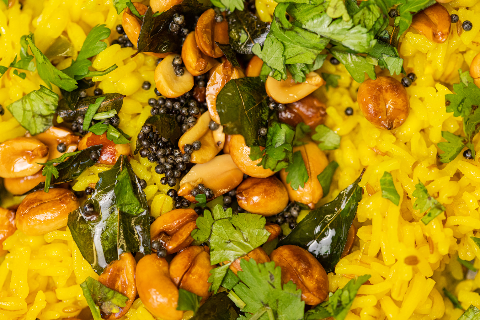 A close up of a plate of food with rice , nuts and vegetables.