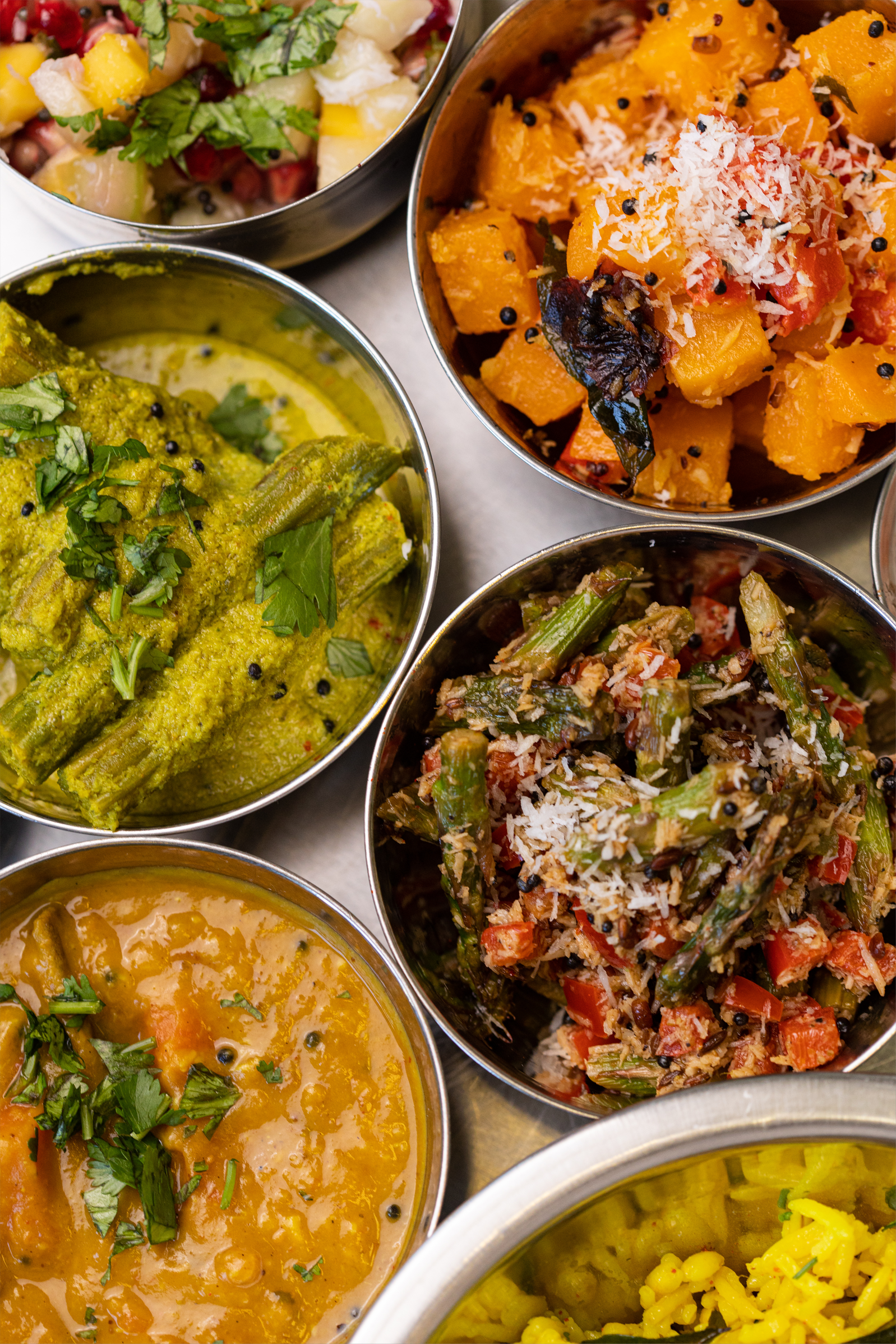 There are many different types of food in the bowls on the table.