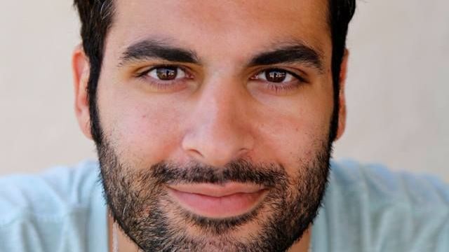 A man with a beard is smiling for the camera.
