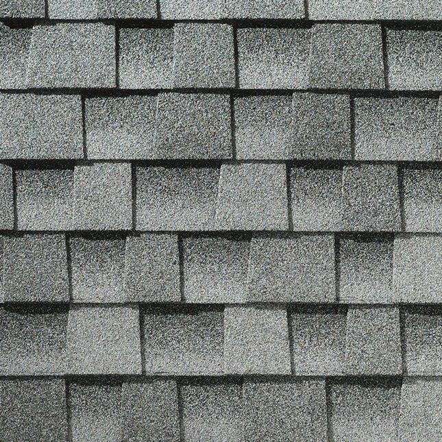 Bardeaux de toiture en asphalte gris disposés en quinconce.