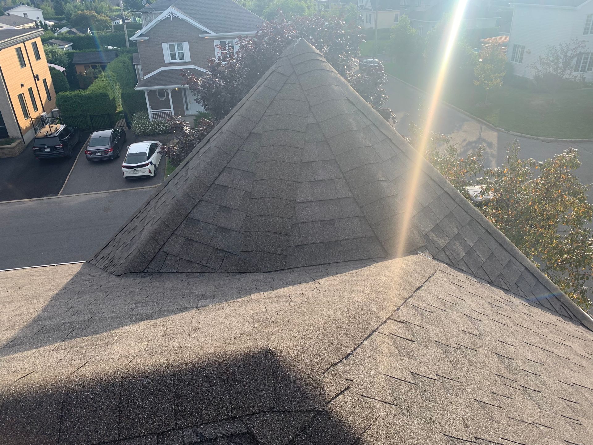 Vue d'un toit à plusieurs côtés et des bâtiments adjacents par une journée ensoleillée.