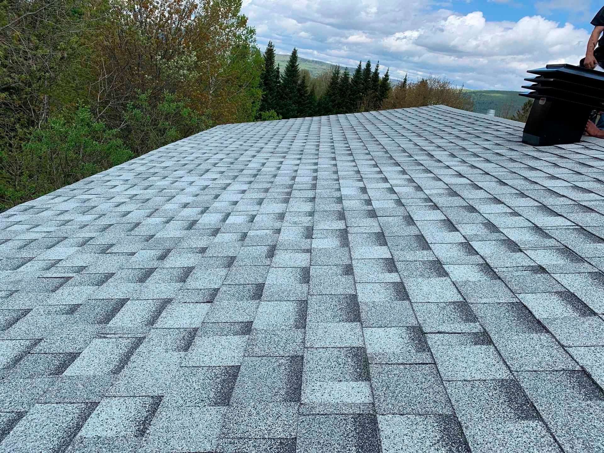 une personne se tient sur le toit d' un bâtiment au coucher du soleil .