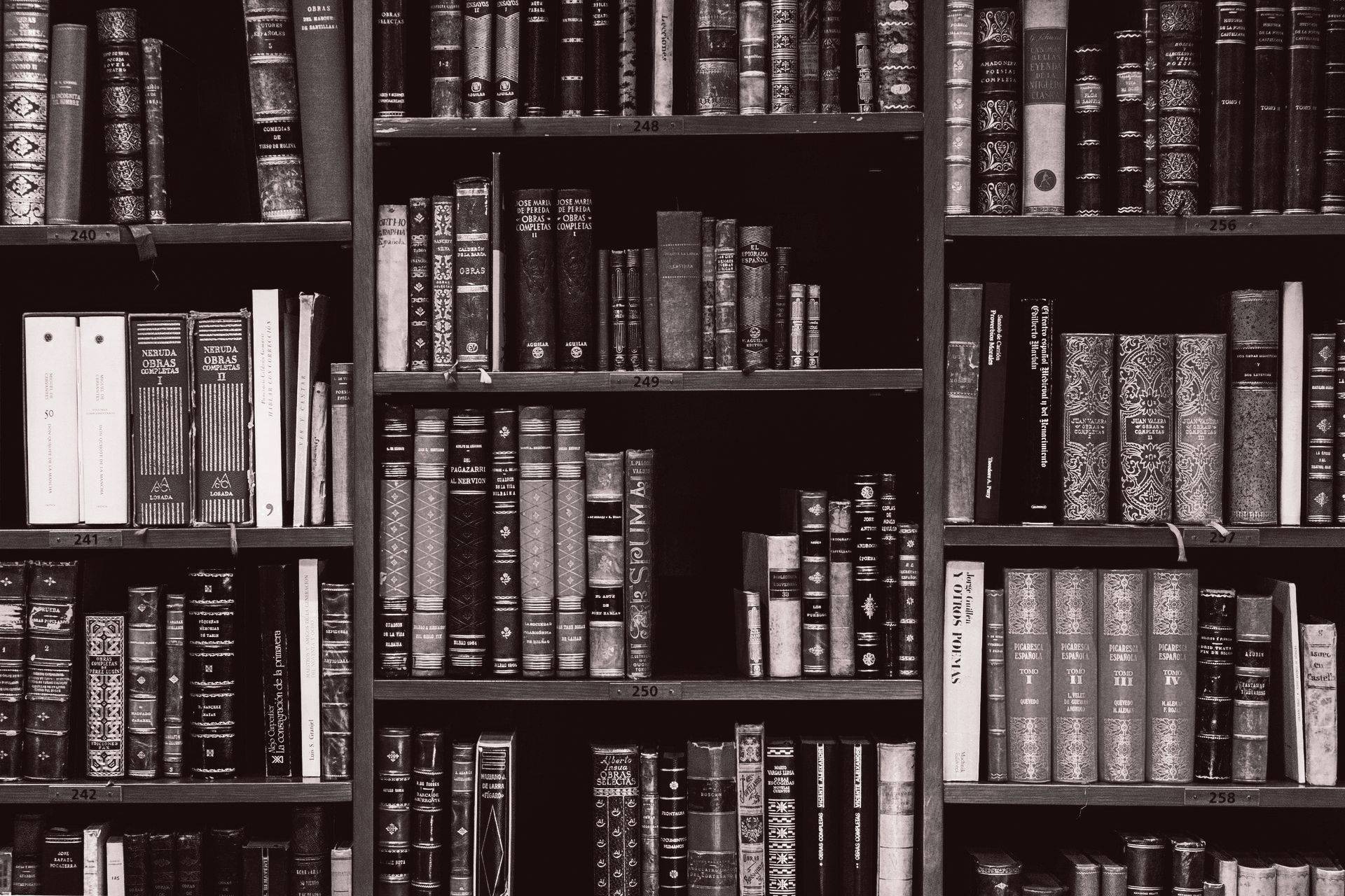 A black and white photo of a library filled with books