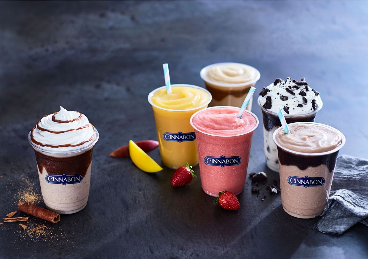 A variety of smoothies are sitting on a table.
