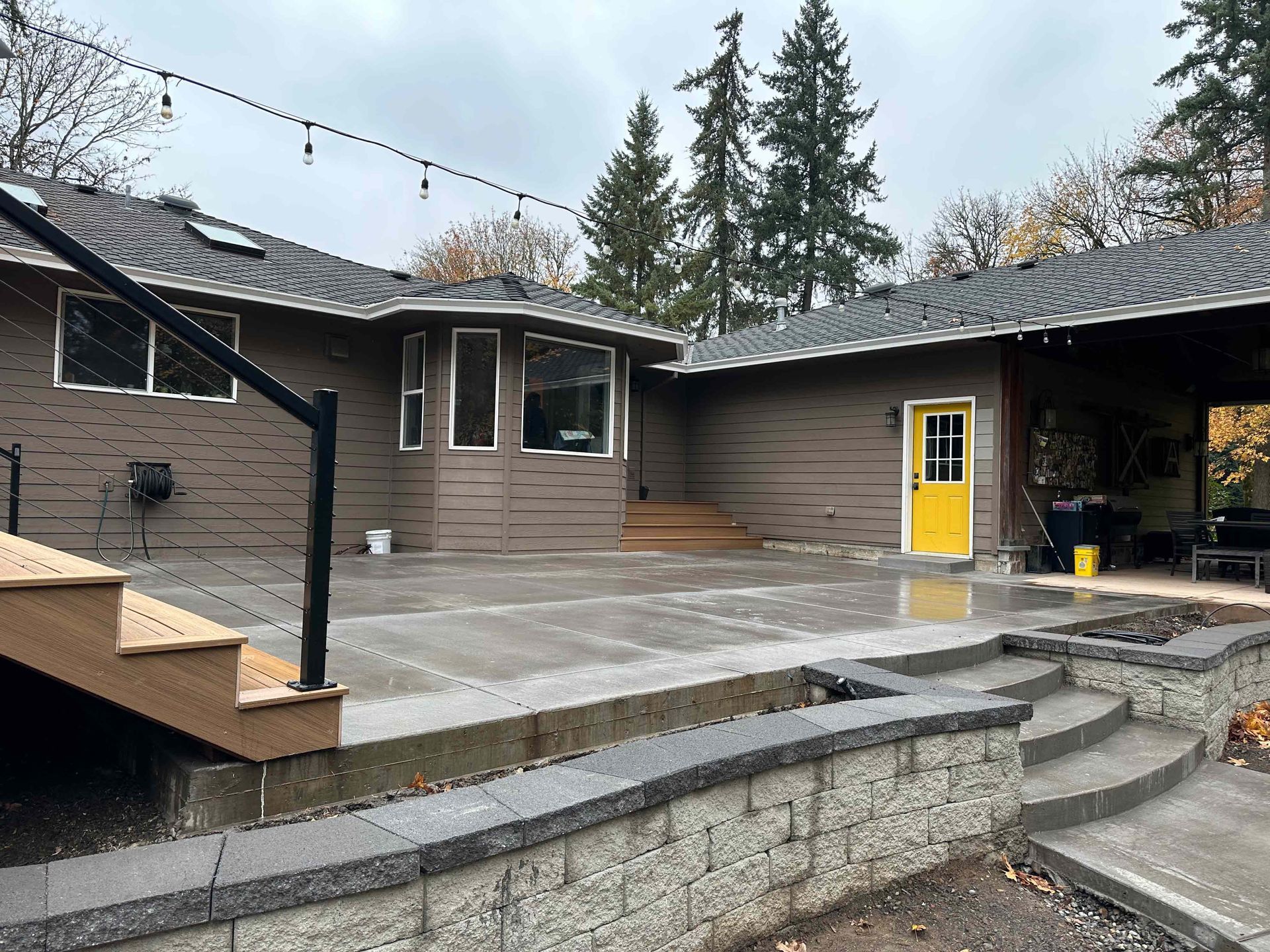 The backyard of a house with a patio and stairs and a yellow door.