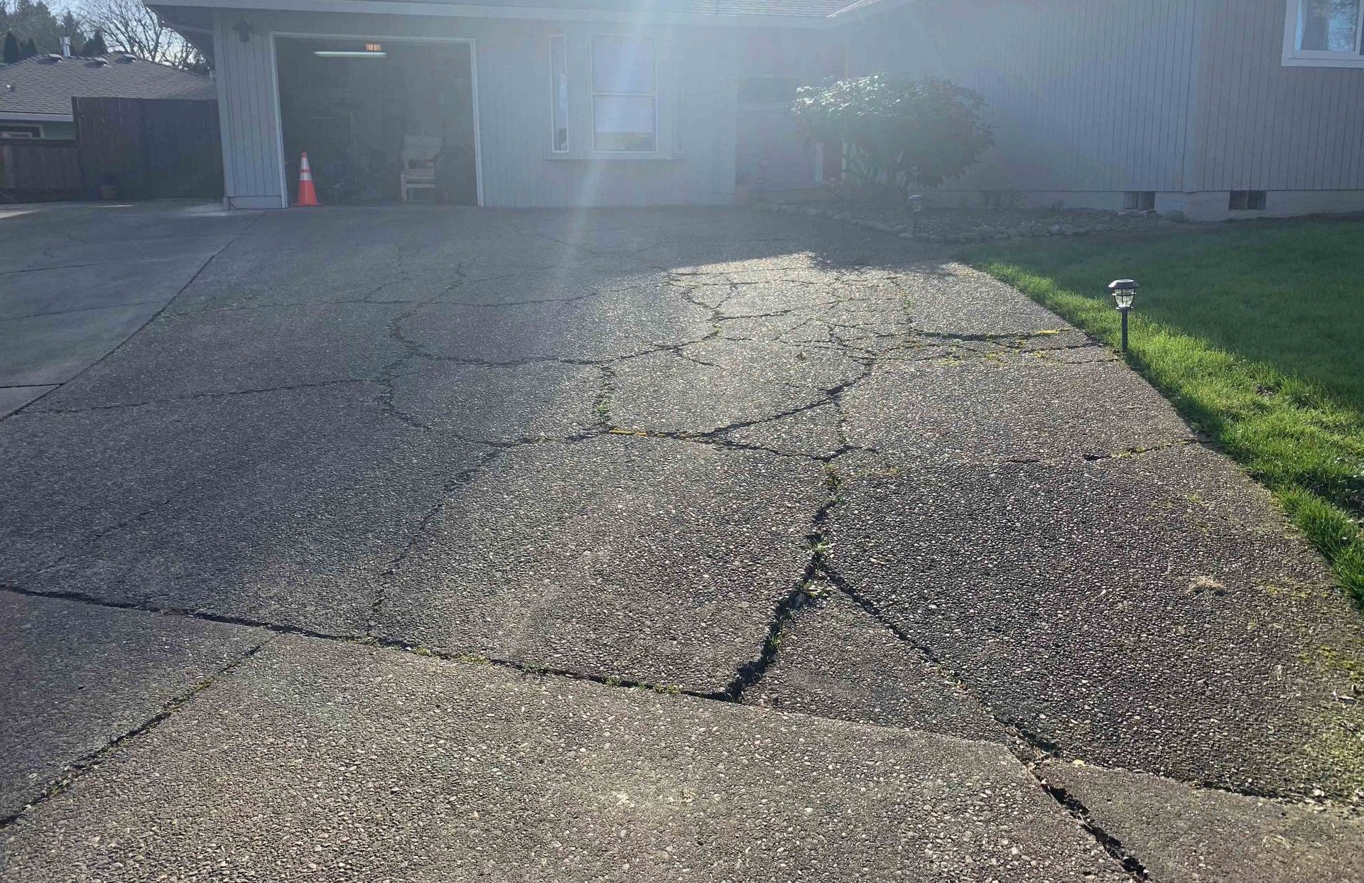 A cracked concrete driveway before repair 