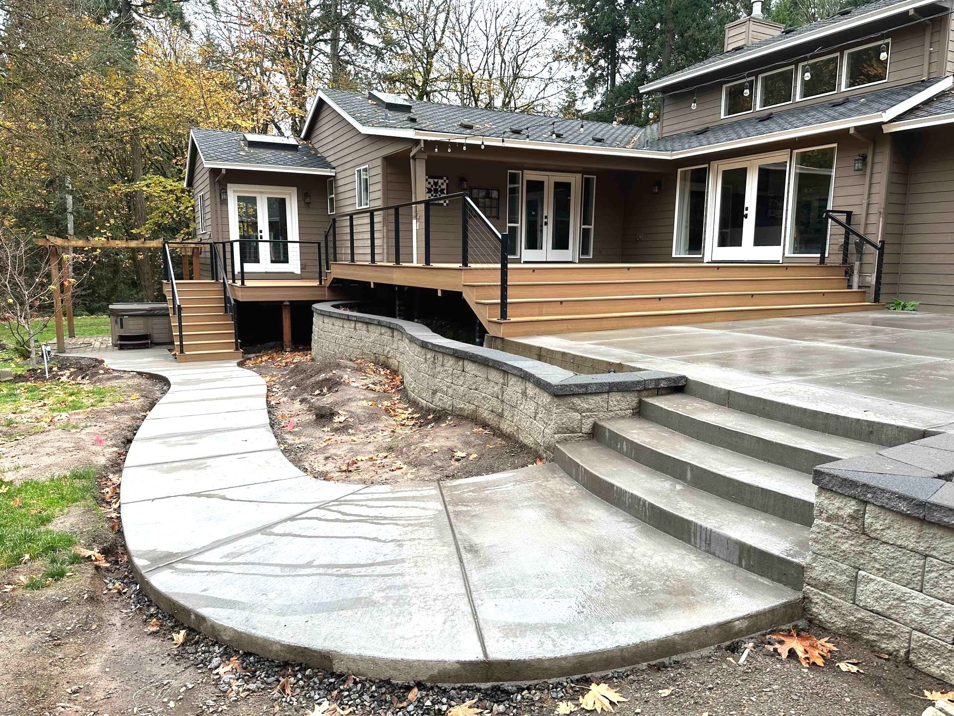 There is a concrete patio walkway leading to the back of the house.