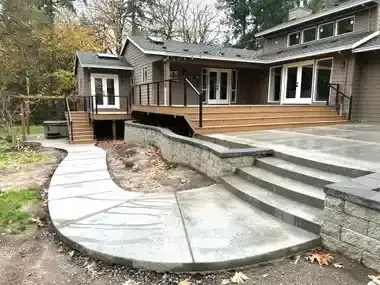 There is a concrete walkway leading to the back of the house.