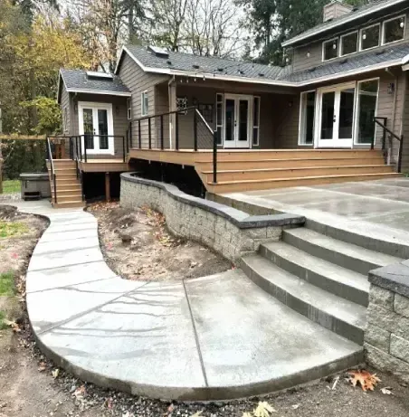 There is a concrete walkway leading to the back of the house.