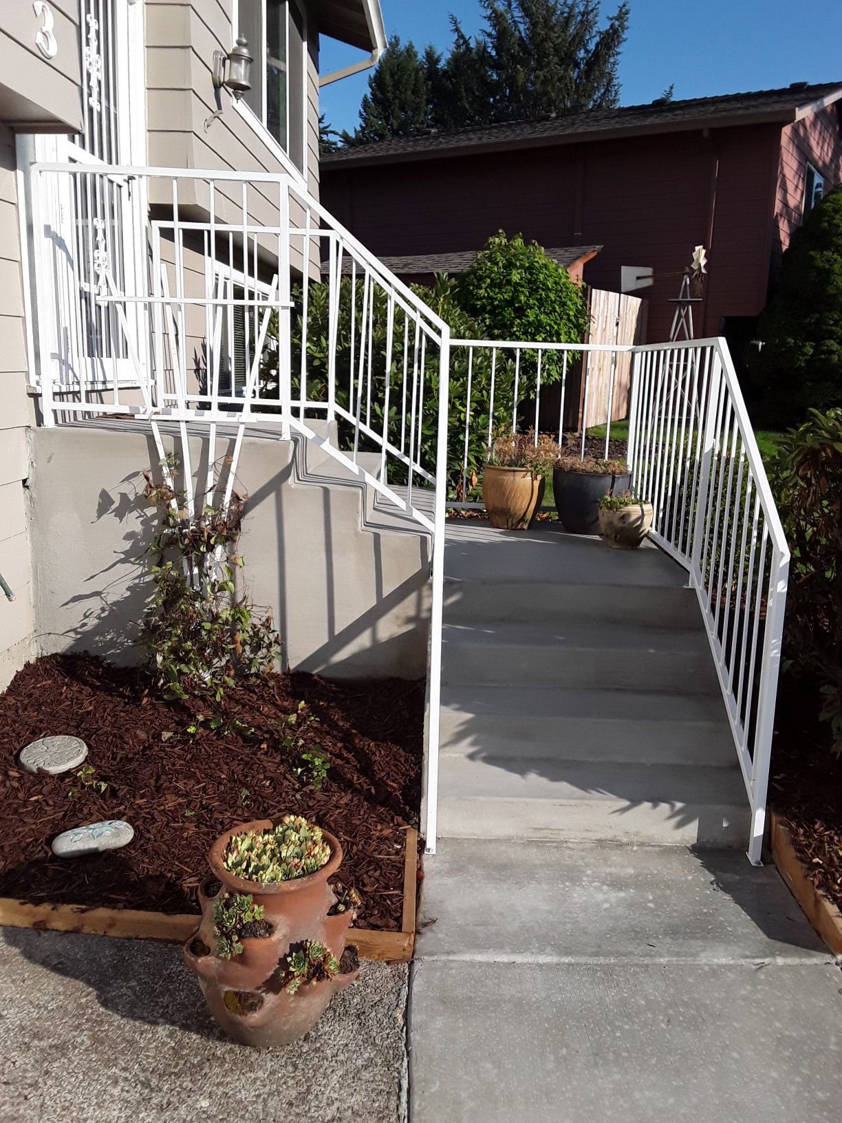 A staircase with a white railing leading up to a house