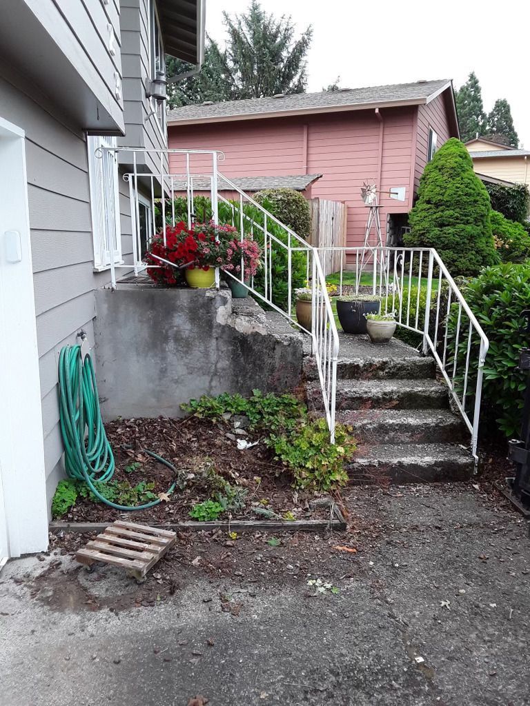 A house with stairs leading up to it and a hose next to it.