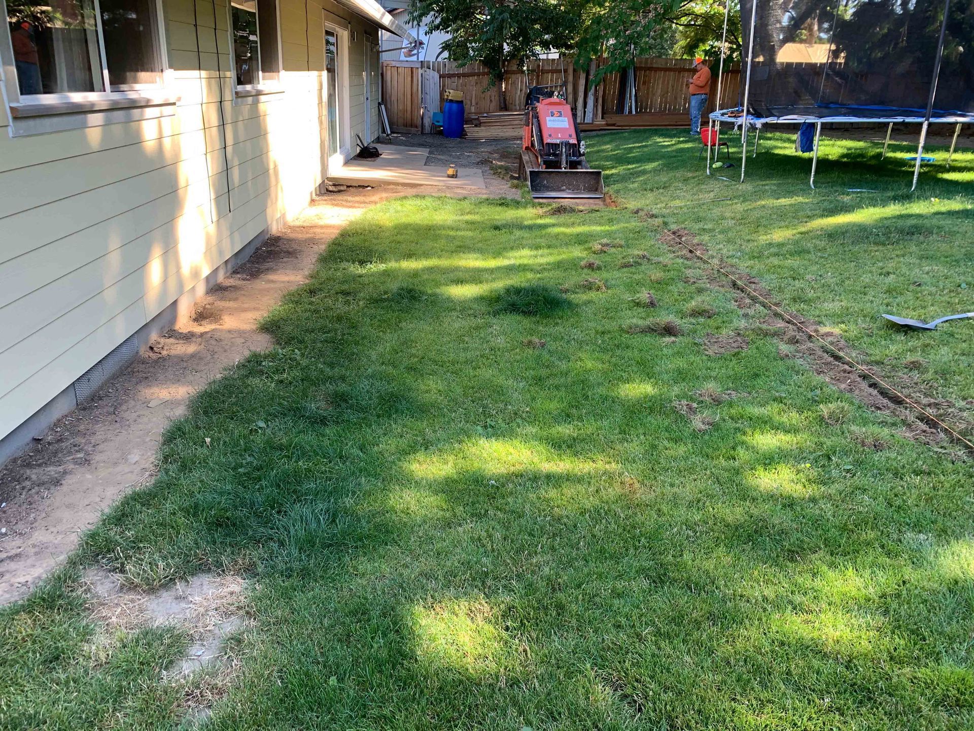 A backyard with a trampoline and a lawn mower in Portland OR