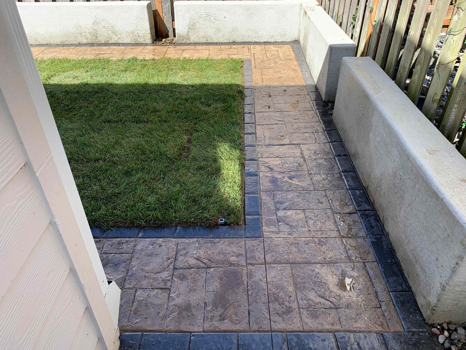 A brick walkway leading to a lush green lawn in Portand OR