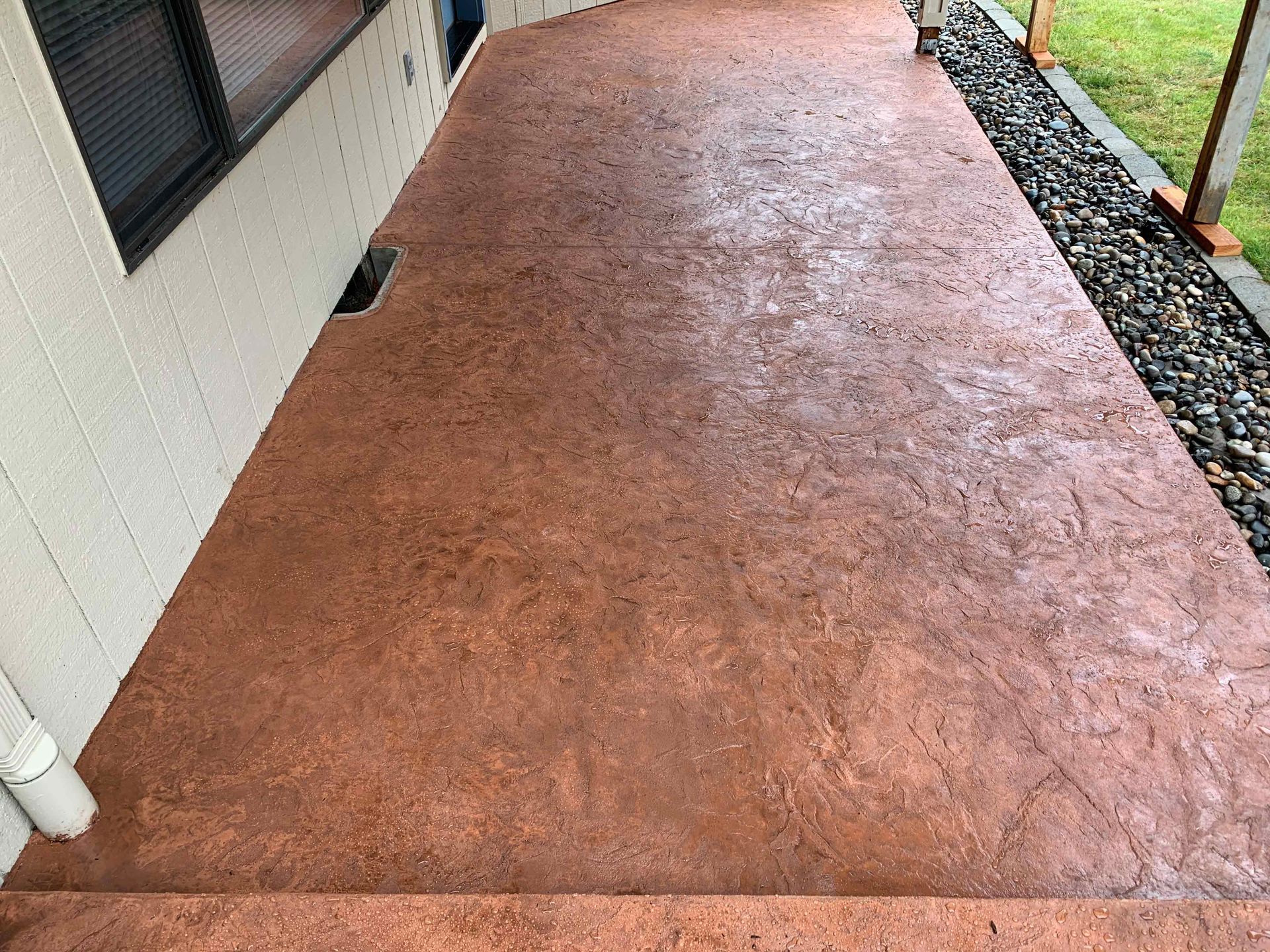 An After Picture of a concrete walkway with stairs leading up to a house.