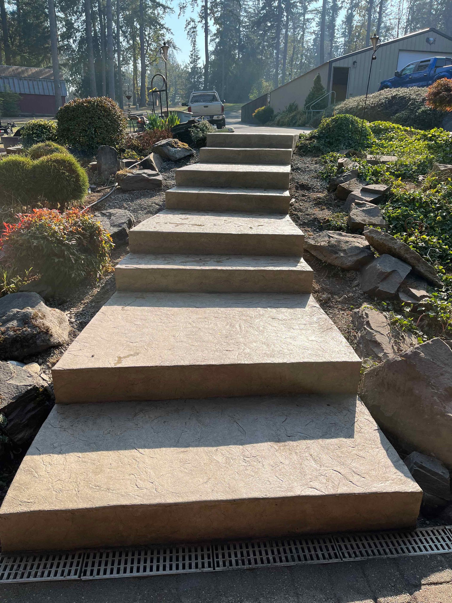 A row of concrete steps leading up to a house in a garden.