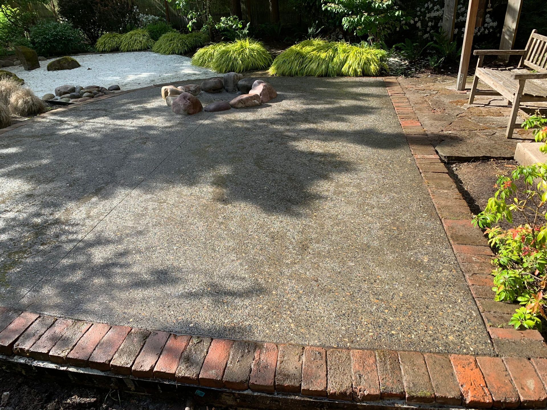 A patio with a brick border and a fire pit in the middle in Portland OR