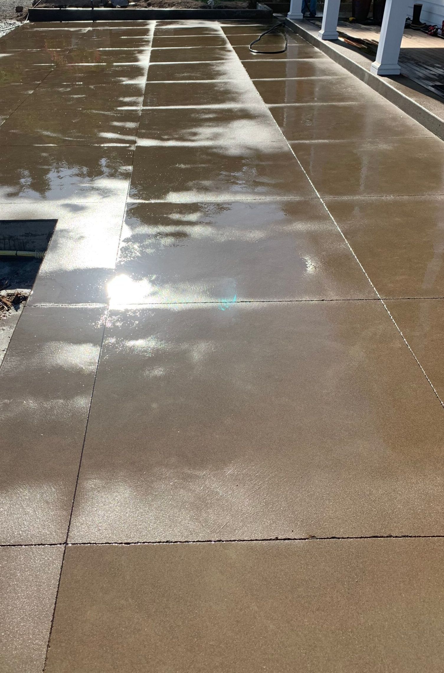 a concrete driveway with a reflection of trees in the water in Portland OR