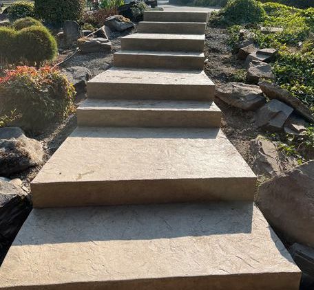 A set of concrete stairs leading up to a rocky area in a garden in Portland OR