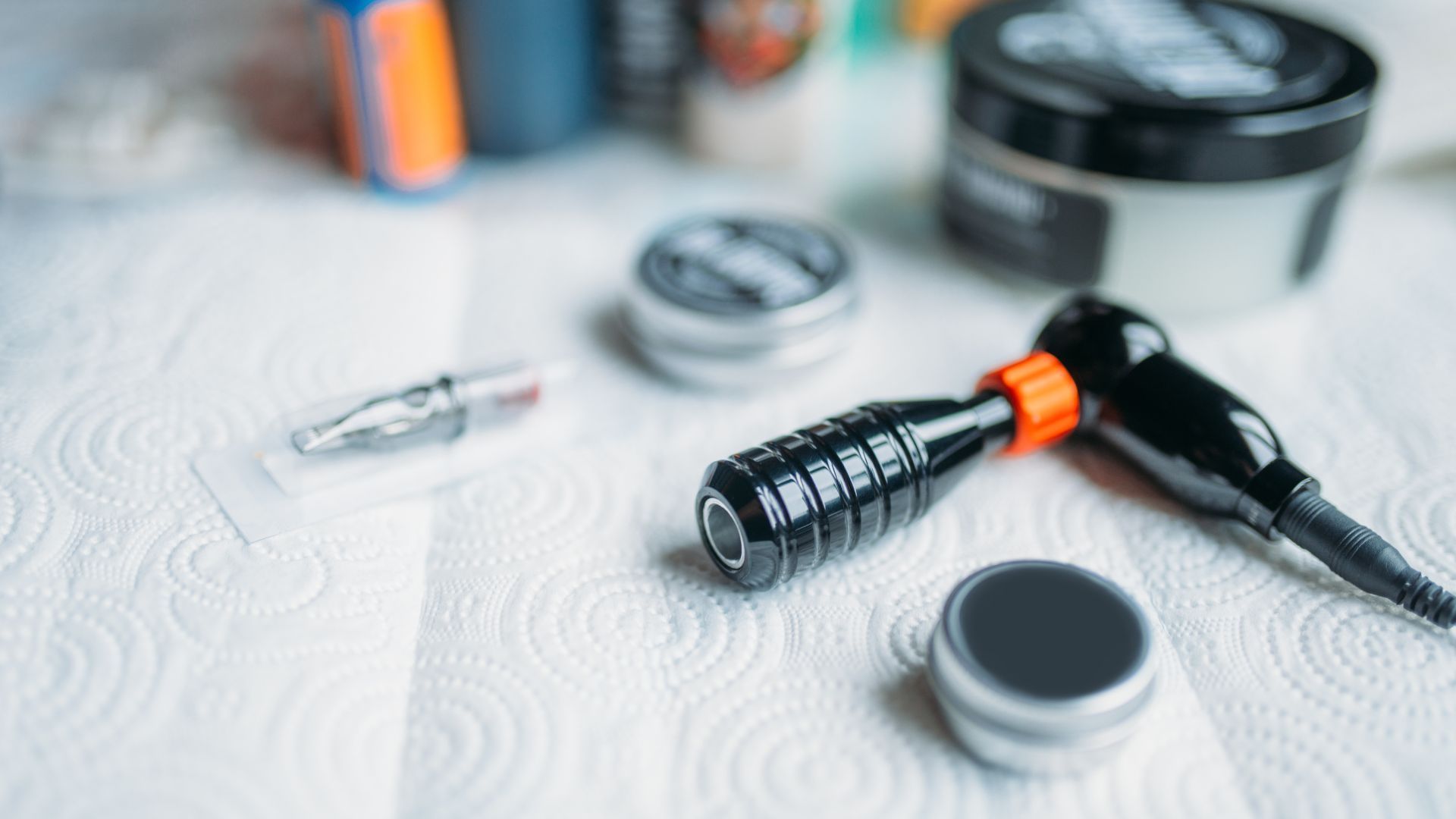 A tattoo machine is sitting on a paper towel on a table.