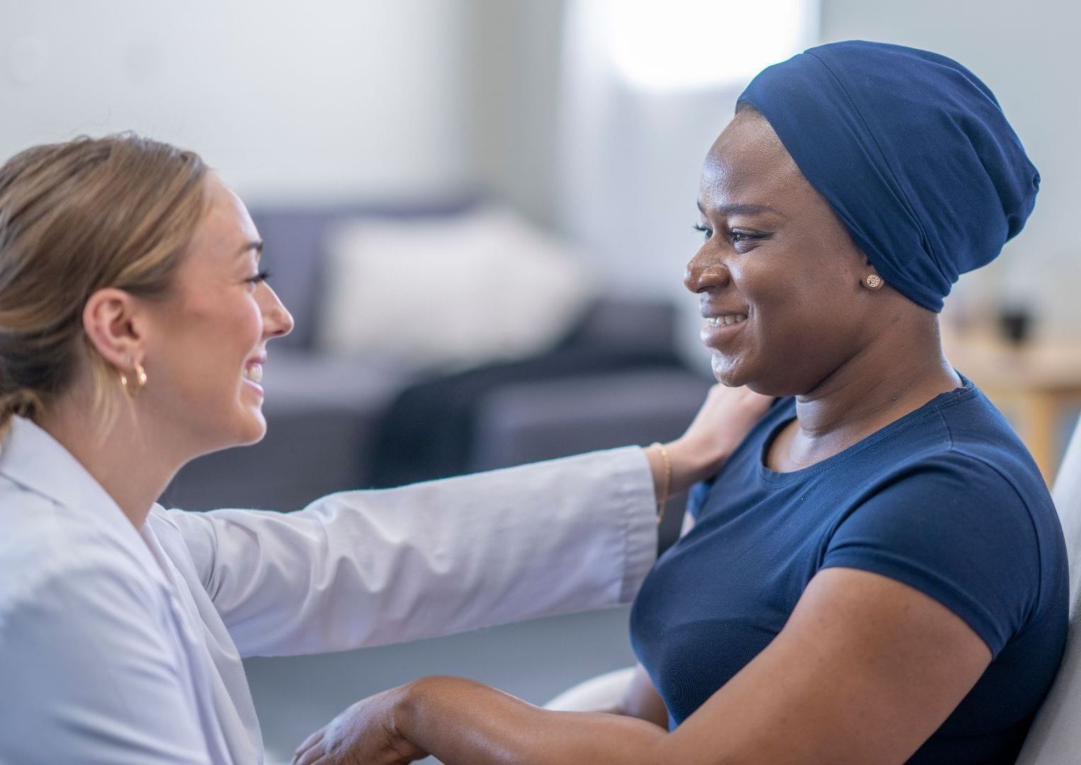 A doctor is holding the hand of a patient with cancer.