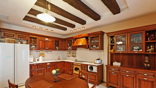 A kitchen with a table and chairs and a refrigerator.