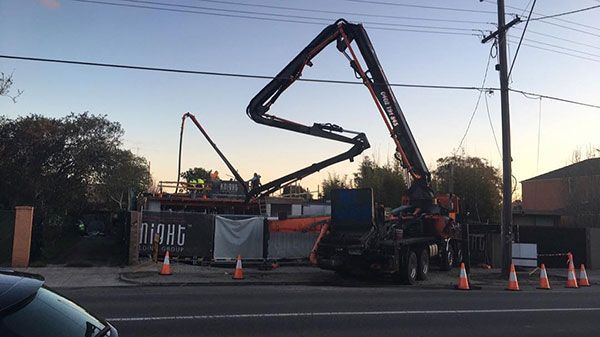 A concrete pump is being used to pour concrete on a construction site.