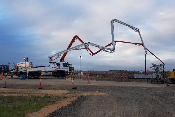 A concrete pump is being used to pump concrete on a construction site.