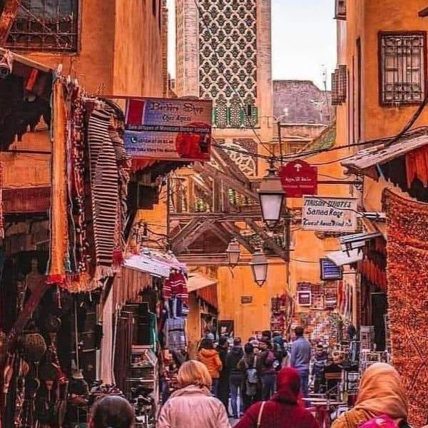 The warm colors of a Moroccan sunset reflecting on the desert dunes.