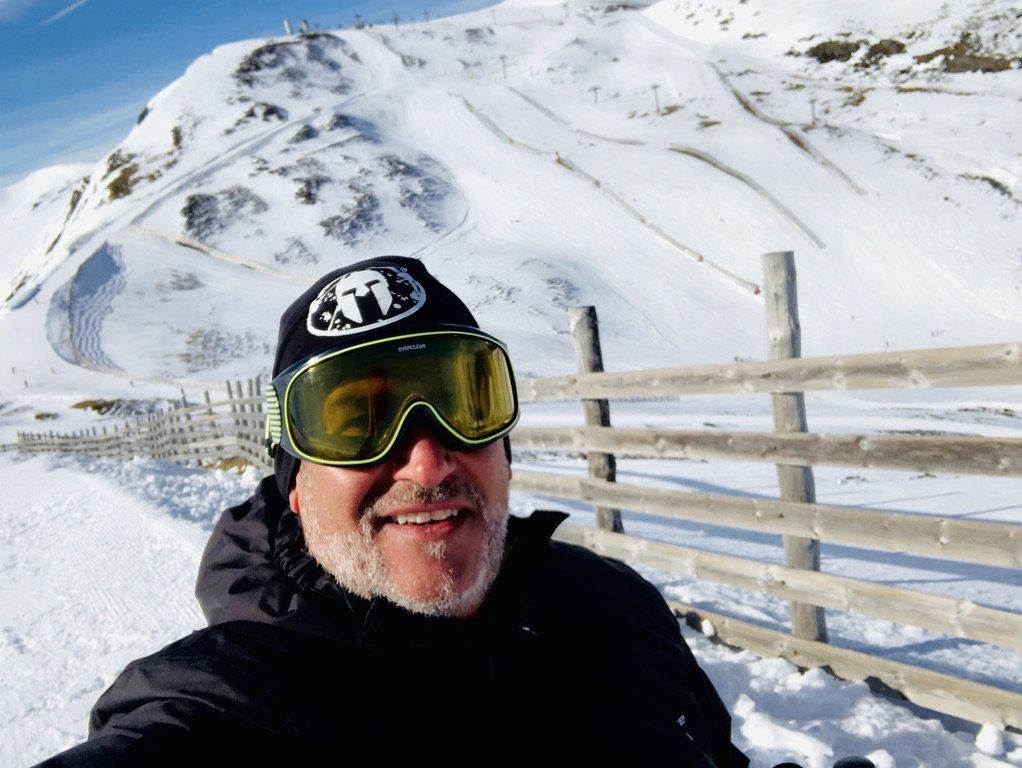 Un hombre que lleva gafas y un sombrero con el simbolo de Spartan