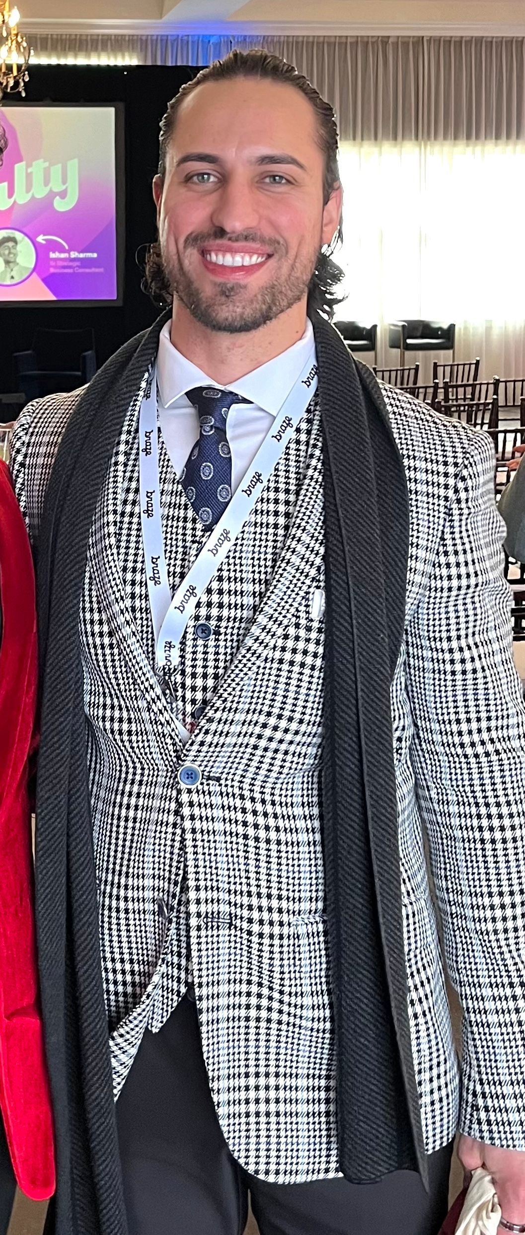 A man in a suit and tie is standing next to a woman in a red coat.