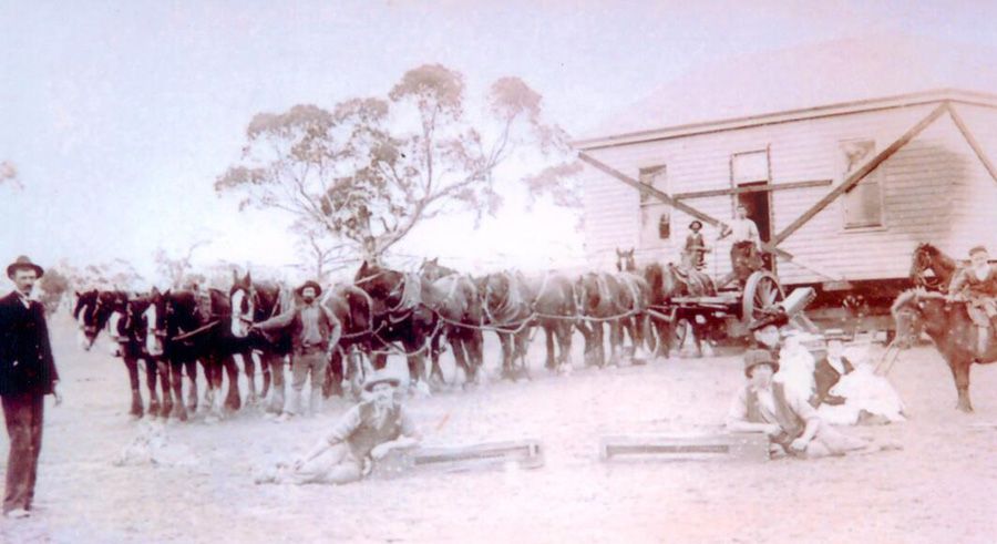 A black and white photo of a group of people standing in front of a building.