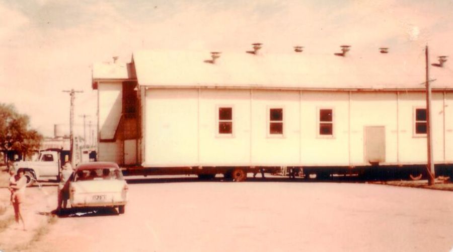 A car is parked in front of a large white building