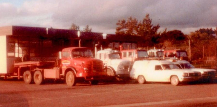 A group of trucks are parked next to each other on the side of the road.