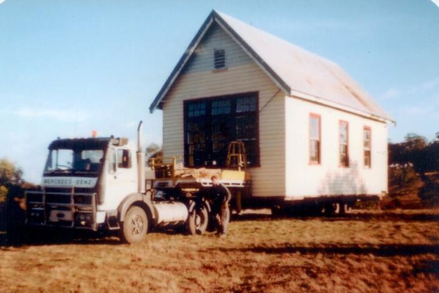 A white truck is pulling a house on a trailer