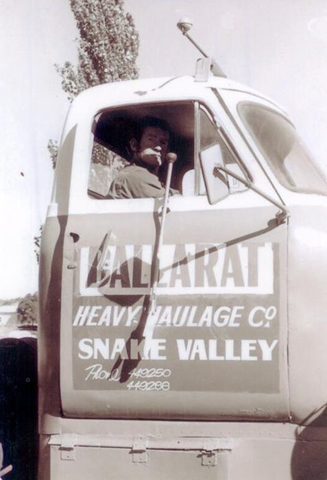A man sits in the driver 's seat of a snake valley truck