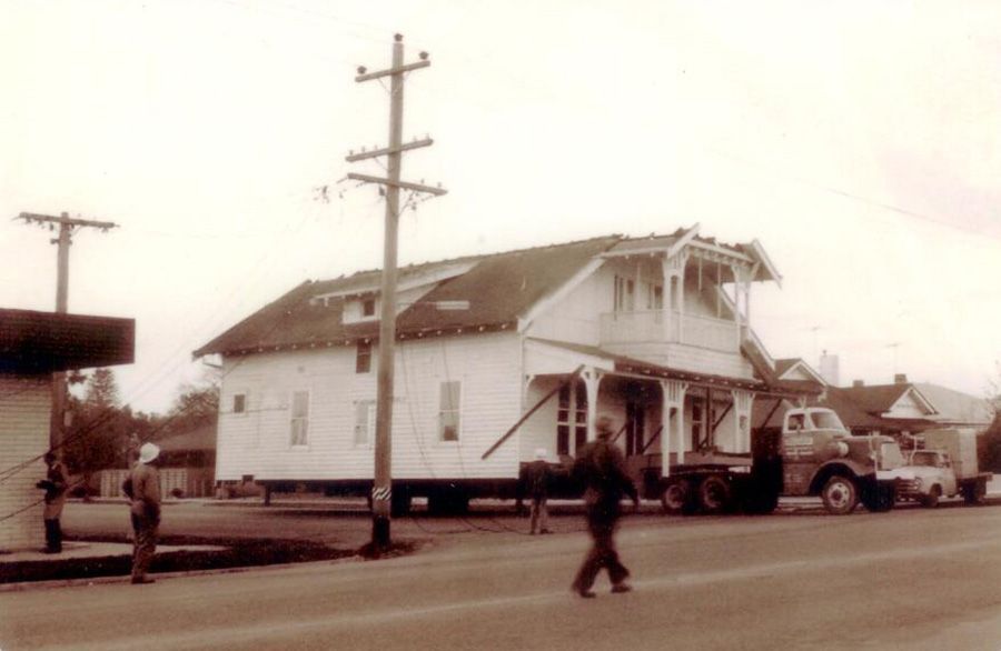 A black and white photo of a house being moved