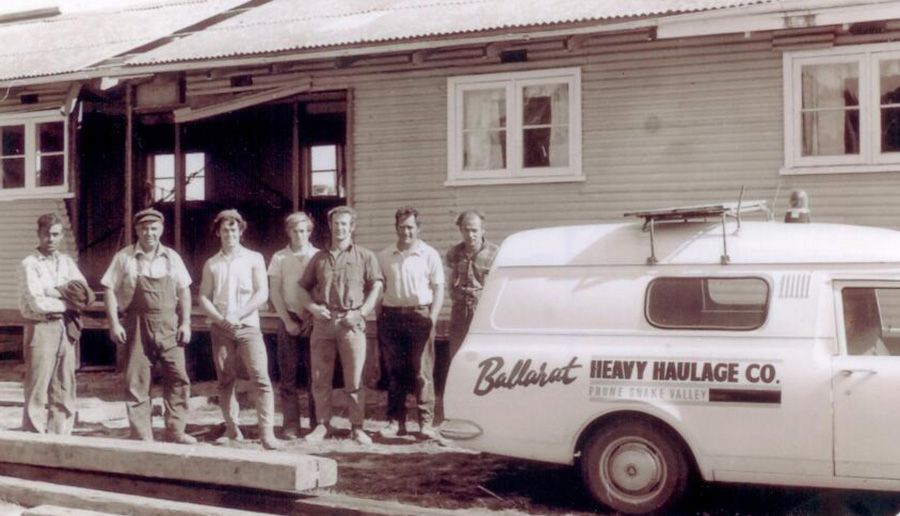 A group of men are standing in front of a white van that says ballast heavy haulage co.