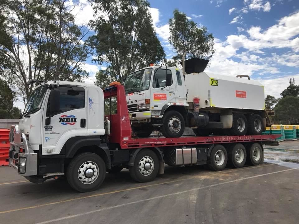 A tractor is on the back of a tow truck