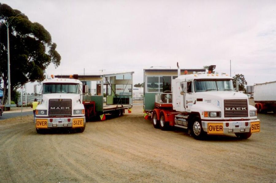 Two mack trucks are parked next to each other