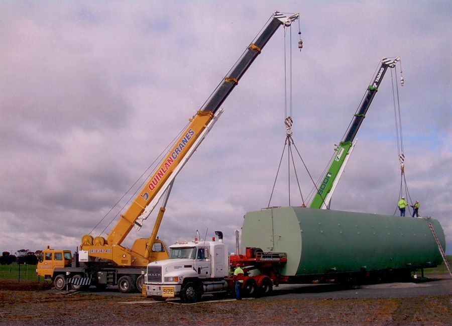 A truck is being lifted by a crane that says ' cargo transport ' on it